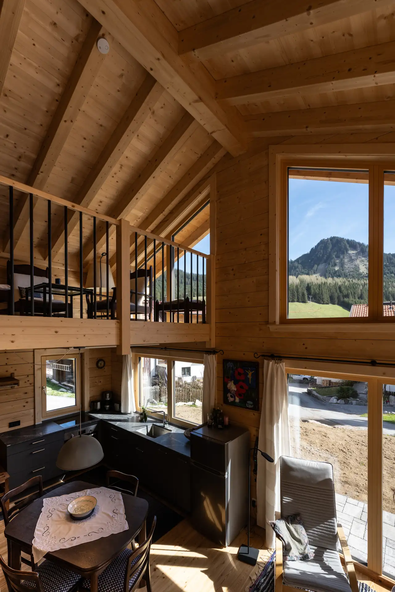 Blick von der Galerie durch das Giebelfenster auf einen Berg bei Berwang